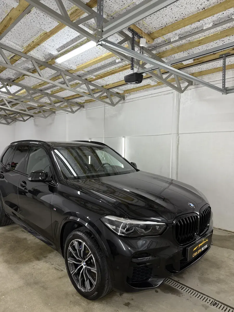 Czarne BMW X5 ustawione bokiem w hali