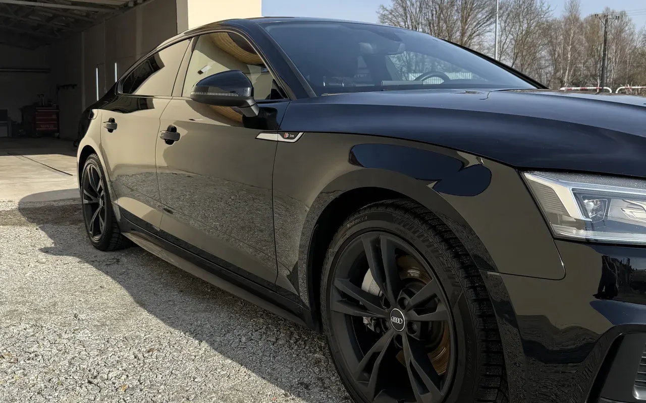 Czarne Audi A5 z odbiciami w lakierze, ujęcie z boku