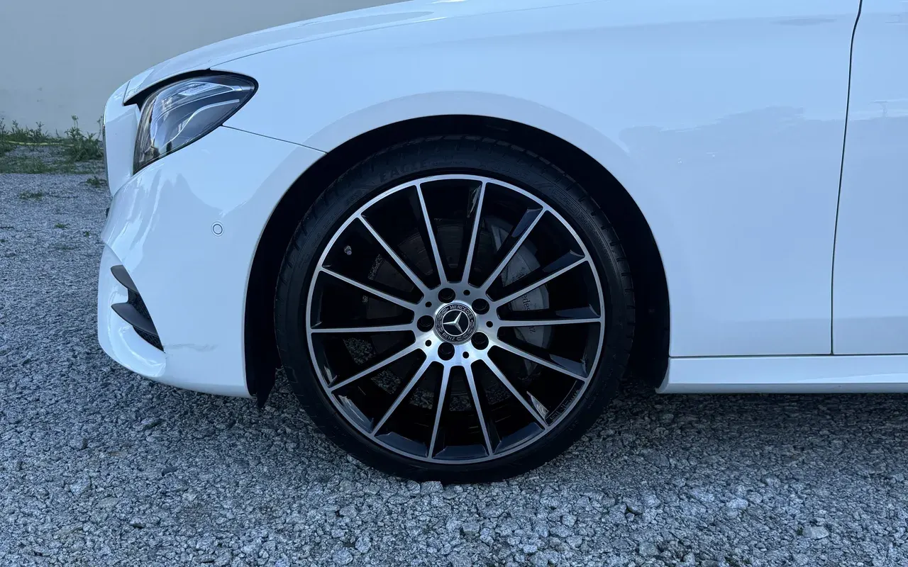 Przód białego Mercedesa, zbliżenie na koło i błotnik