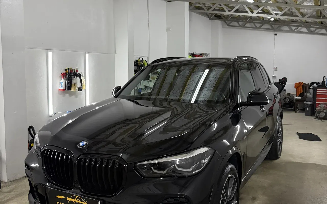 Przód czarnego BMW X5 w hali, lakier z głębokim połyskiem
