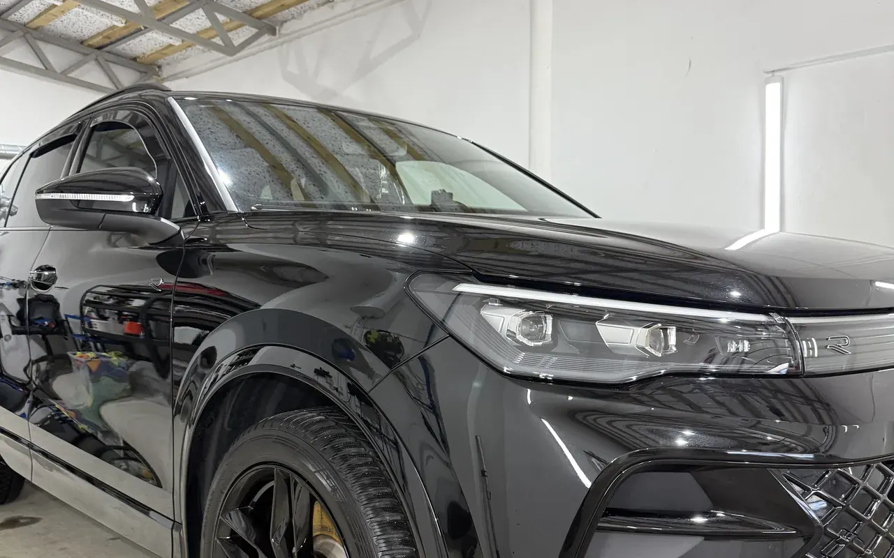 Bok czarnego SUV-a, widoczne szyby boczne i przednia